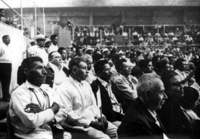 Políticos durante una asamblea en un campo deportivo