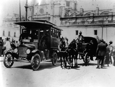 Camión urbano y carruaje al pasar por una calle