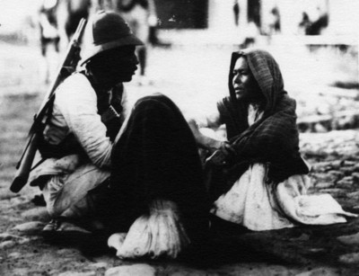 Soldadera y soldado con una niña sentados en el suelo