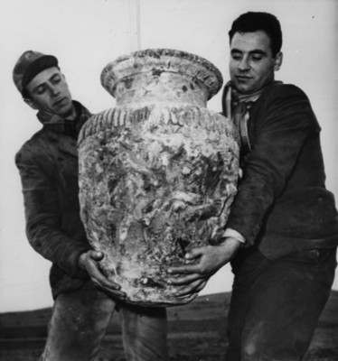 Hombres sostienen jarrón de cerámica