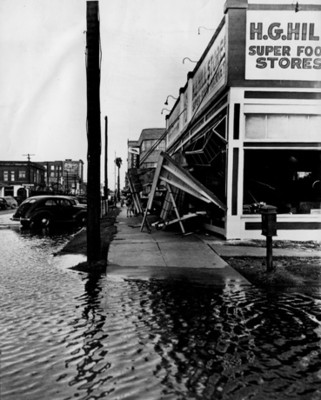 Gente observa calle inundada, vista parcial