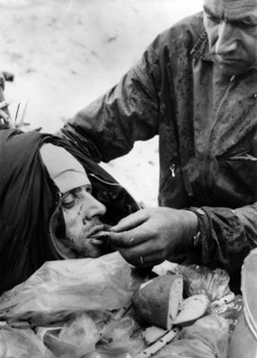 Herido recibe alimentos de manos de un socorrista