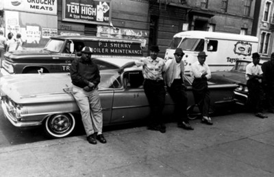 Hombres recargados en un automóvil, retrato de grupo