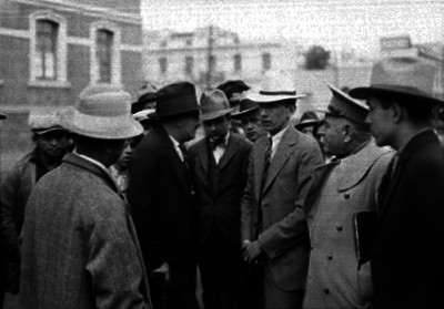 Valente Quintana teniendo una conversación con policías y fucionarios públicos en una calle