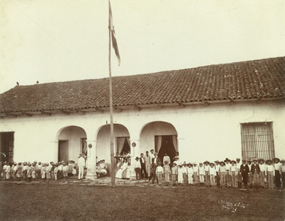 Niños y maestros afuera de su escuela, retrato de grupo