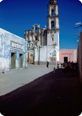 Vida cotidiana en una calle, al fondo la iglesia