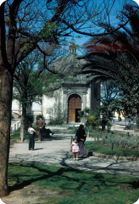 Gente en jardin frente a una iglesia