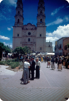 Gente en plaza publica frente a una iglesia