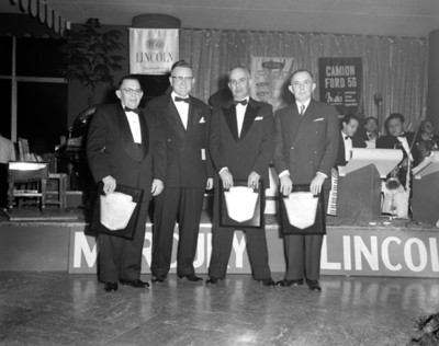 Hombres muestran reconocimientos durante evento de la empresa Ford, retrato