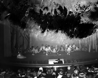 Público observa a niños bailarines durante representación teatral