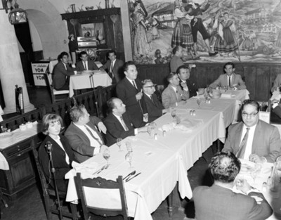 Hombre pronuncia discurso a los asistentes al banquete en un restaurante