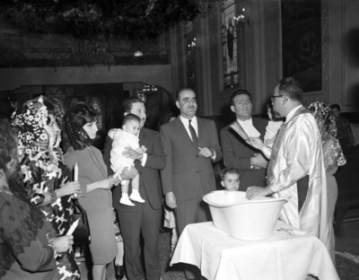 Sacerdote le lee la biblia durante ceremonia de bautizo