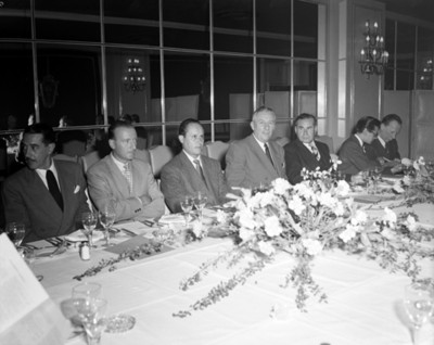 Hombres en mesa de un salón durante banquete, retrato de grupo