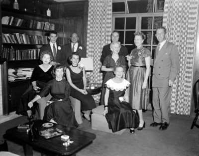 Hombres y mujeres durante reunión social en la sala de una casa, retrato de grupo