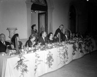 Hombres y mujeres durante banquete en un salón