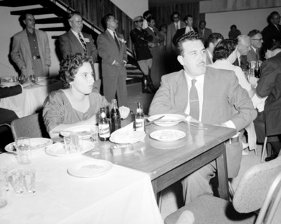 Gente comen en un restaurante frente de una escalera