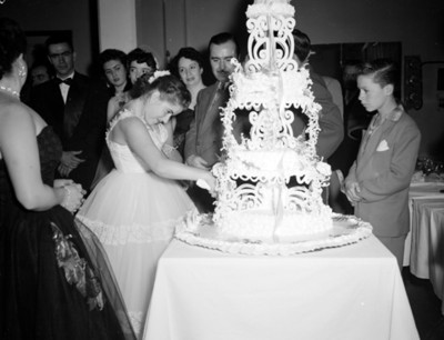 Quinceañera parte su pastel durante fiesta