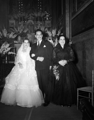 Familia frente a un altar religioso en una iglesia durante quinceaños, retrato de grupo
