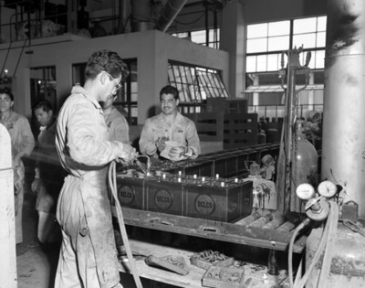 Hombres laboran en fabricación de baterias automotrices DELCO