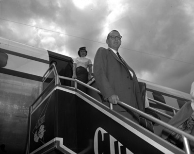 Empresarios y azafata en las escaleras de un avión, retrato