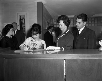 Eva Sámano observa firmar libro a mujer durante visita al INPI