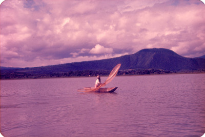 Pescador con red a bordo de canoa en el