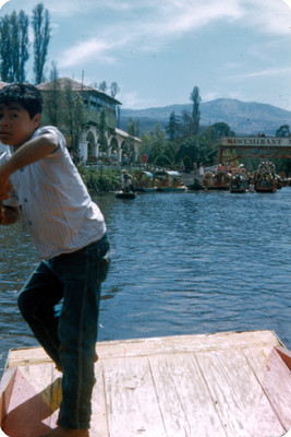 Niño en trajinera frente al embarcadero en Xochimilco