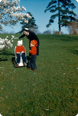 Edith Sophie y sus hijos observan un arbol de flores blancas en un parque