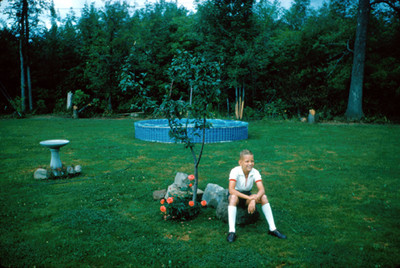 Niño sentado junto a un arbol en el jardin