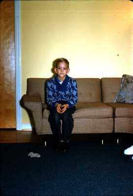 Niño sentado en sillon de una sala