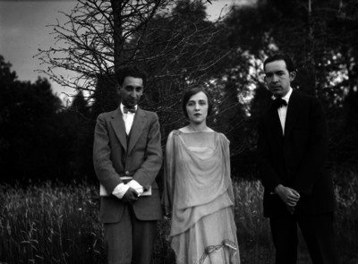 Bertha Singerman acompañada por dos hombres vestidos de traje, en un paraje, retrato