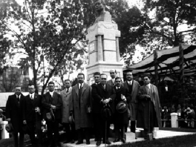 Alvaro Torre Diaz acompañado de varios hombres junto a un monumento al parecer durante un homenaje, retrato de grupo
