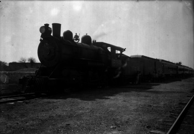 Ferroppcarrileros y otras personas junto a un carro de pasajeros, retrato de grupo