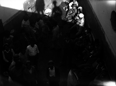 Hombres detenidos en barandilla de una comisaría