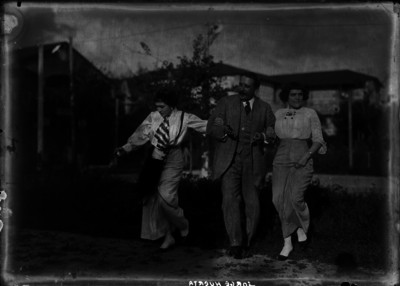 Jorge Huerta abrazando a dos mujeres mientras caminan en un jardín