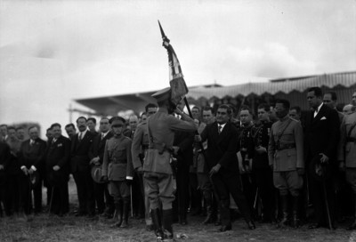 Emilio Portes Gil entregando la bandera al Coronel Reynaldo Pérez Gallardo