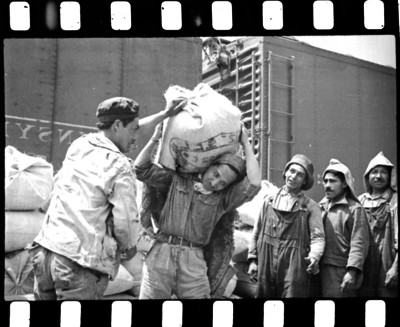 Hombres cargando bultos de alimentos básicos
