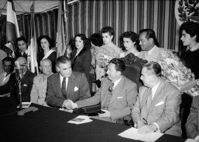 Miguel Alemán Valdés acompañado por funcionarios y mujeres con banderas, en una ceremonia