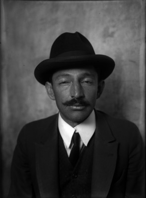 Detenido vistiendo traje y sombrero, retrato