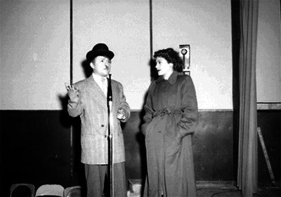 Joaquín García "Borolas" hablando por el micrófono en compañía de una actriz en el escenario de un teatro