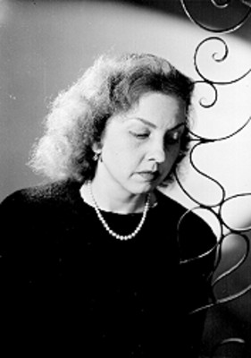 Guillermina Garza Evia, bailarina, recargada junto a una escenografia, porta blusa de cuello redondo, retrato de perfil